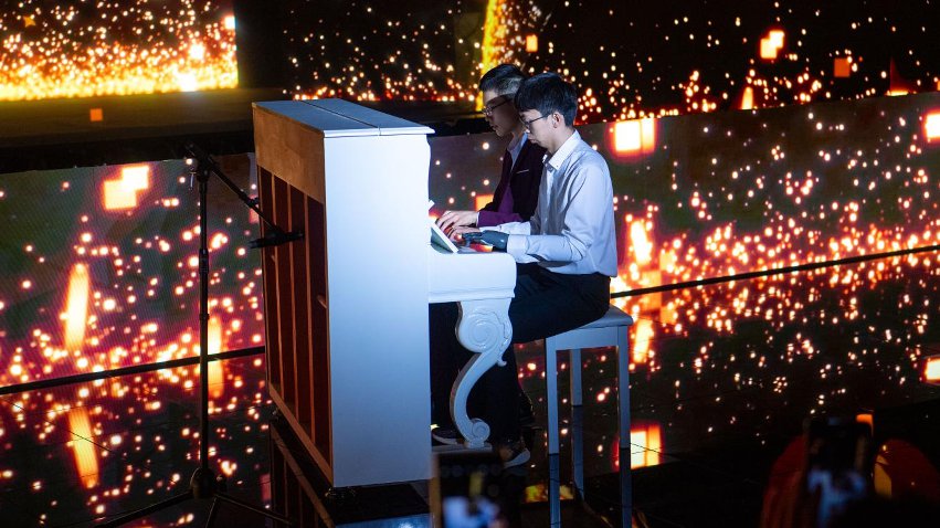 智能仿生手使用者古月與少年鋼琴家舒海峰合奏。主辦方供圖