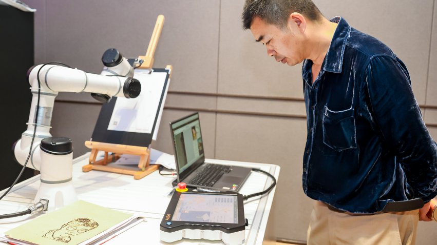 嘉賓體驗(yàn)遨博AI繪畫(huà)機(jī)器人。主辦方供圖